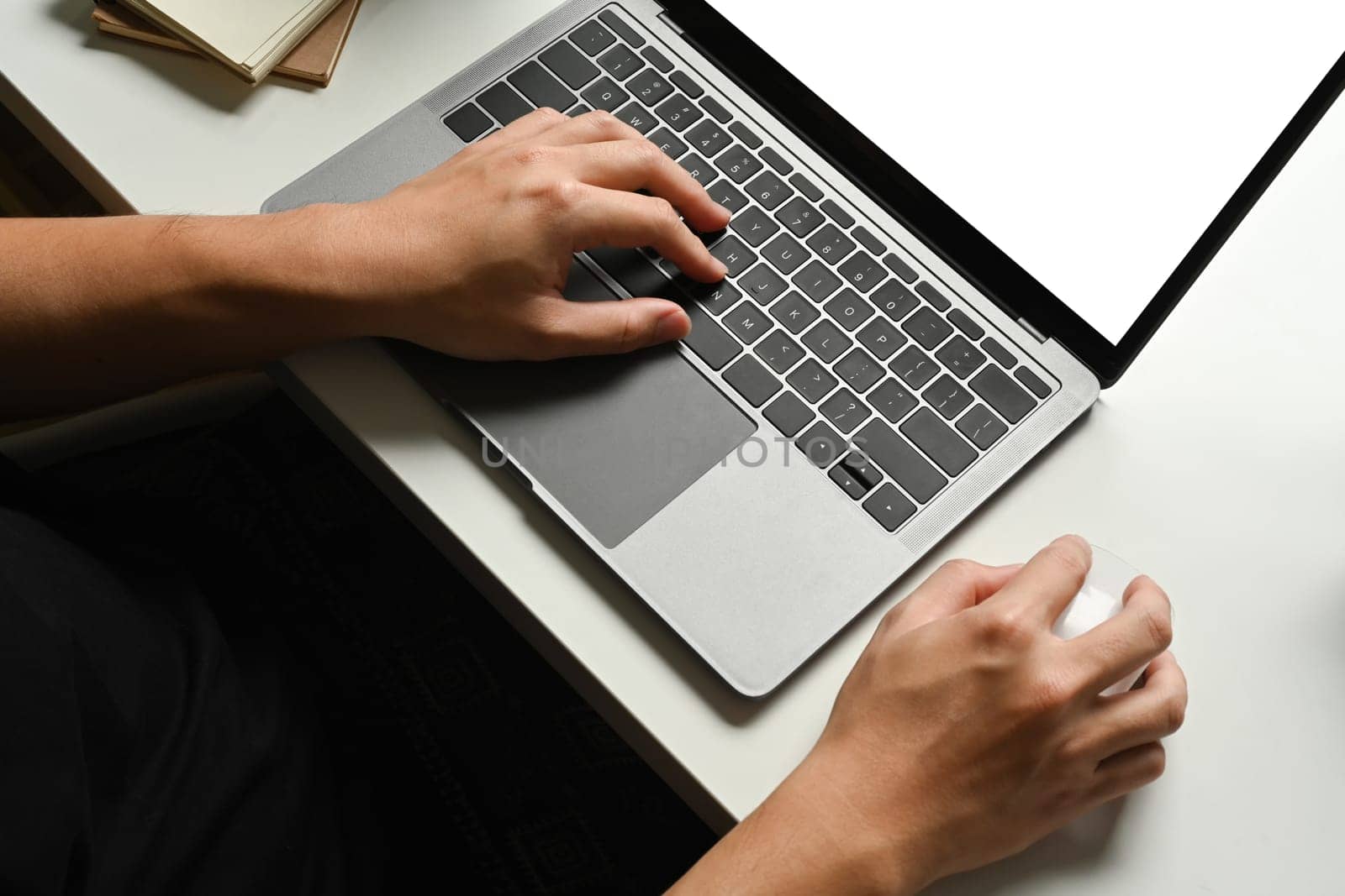 Close up view of hand typing on keyboard of laptop computer at working desk.