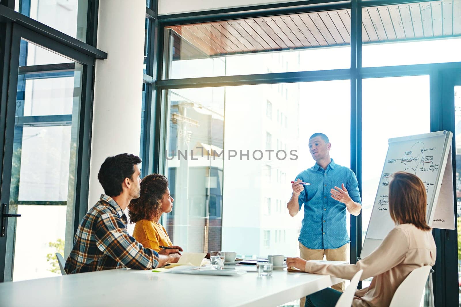 Effective communication is the cornerstone of success. a young businessman giving a presentation in the boardroom. by YuriArcurs