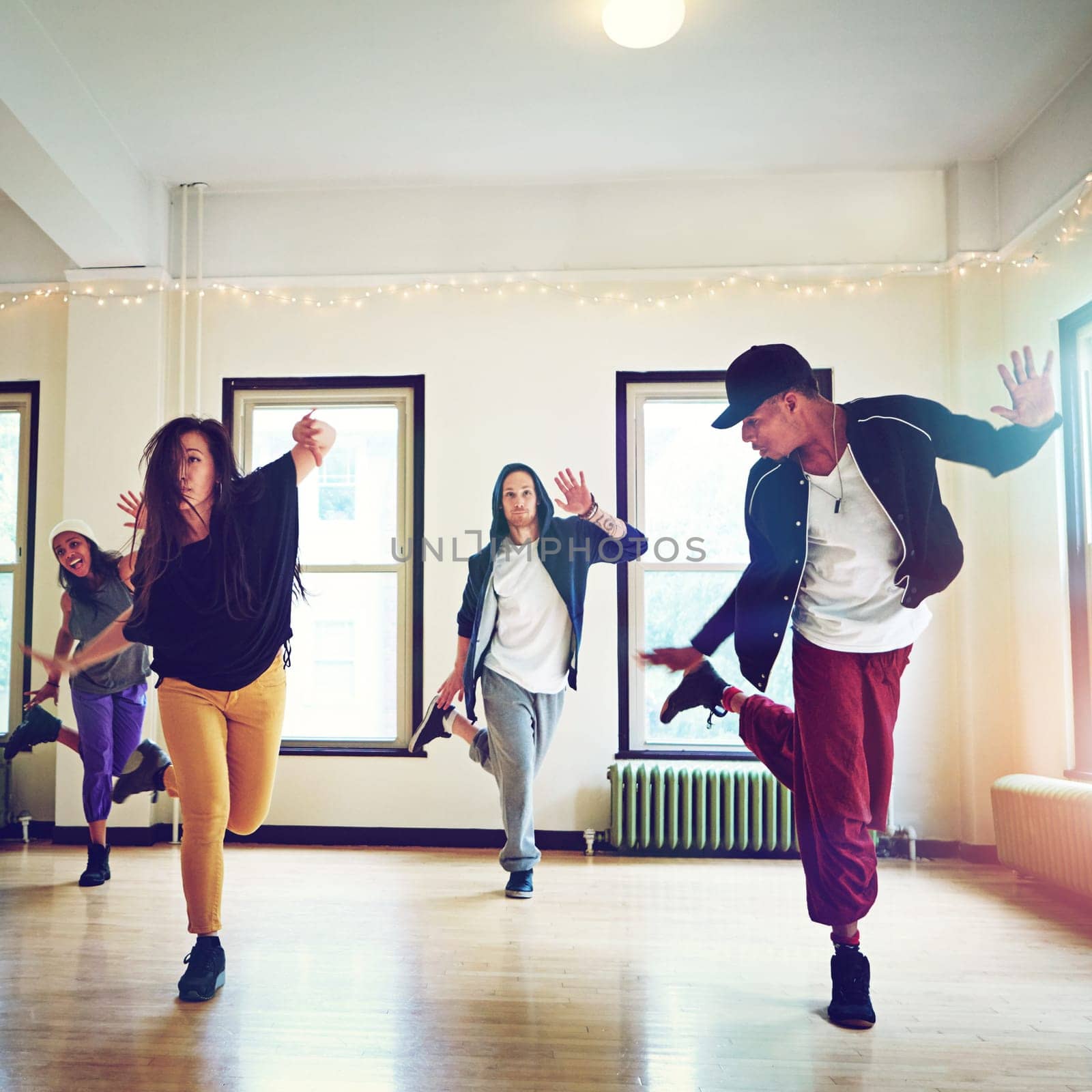 Taking the dance world by storm. a group of young people dancing together in a studio. by YuriArcurs