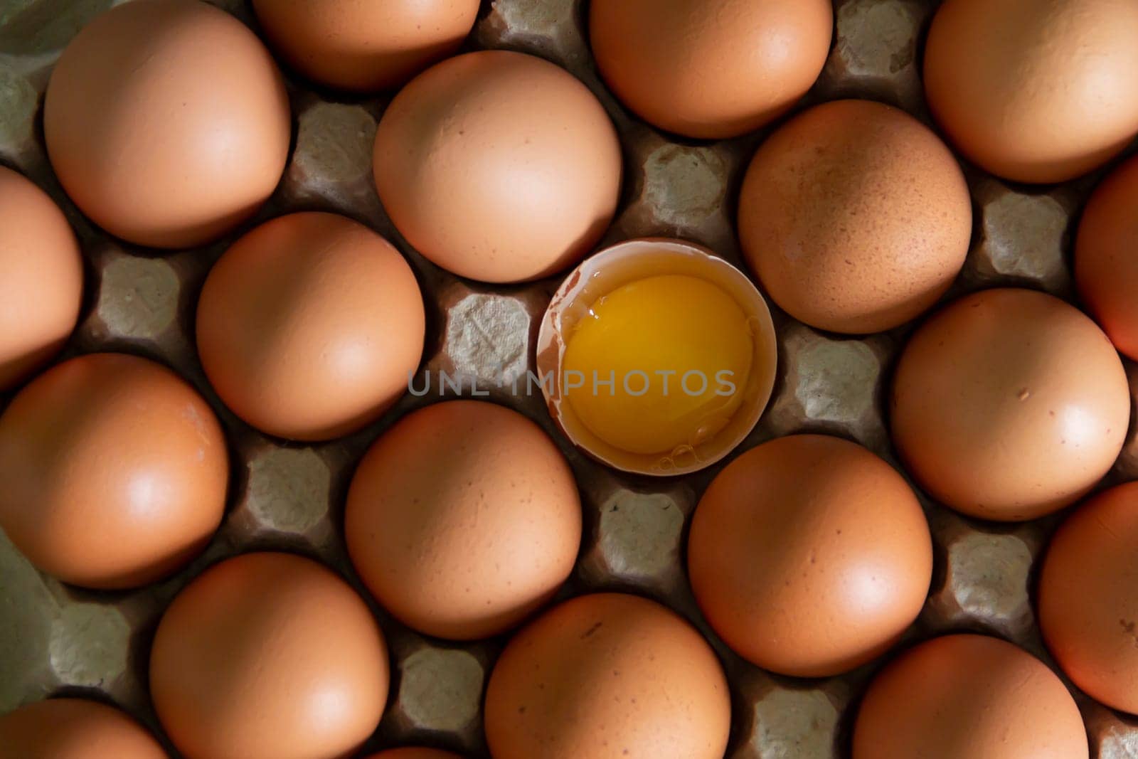 Chicken eggs lie in a tray on the kitchen surface with a broken yellow yolk. Buying products and goods in the store. by Alla_Yurtayeva
