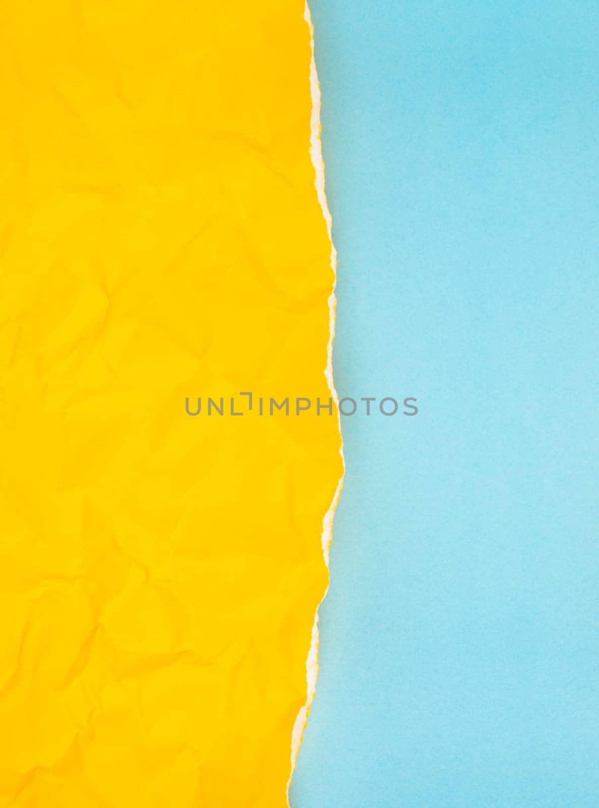 The Vertical torn yellow paper over blue background. by Gamjai