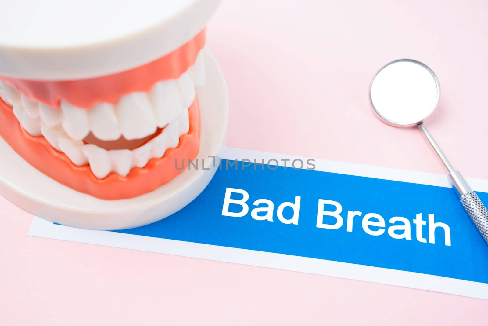 Teeth model with Bad Breath dental disease on pink color background.