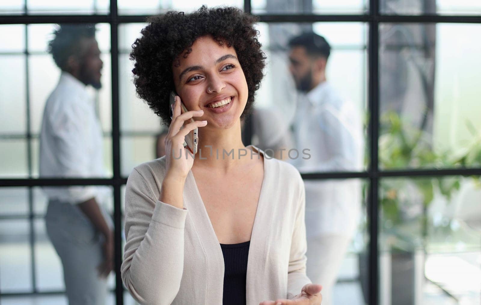 Businesswoman sitting in office, talking on the phone