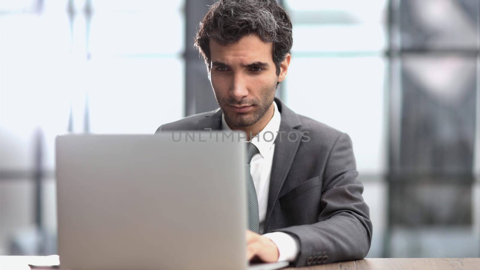 Successful businessman working inside office, man in business suit working at workplace with documents and laptop
