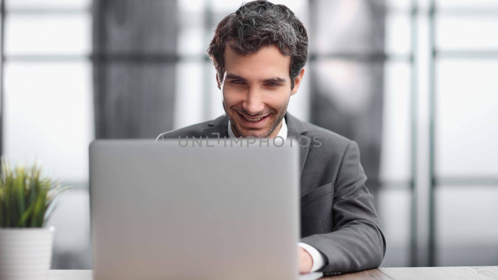 Successful businessman working inside office, man in business suit working at workplace with documents and laptop
