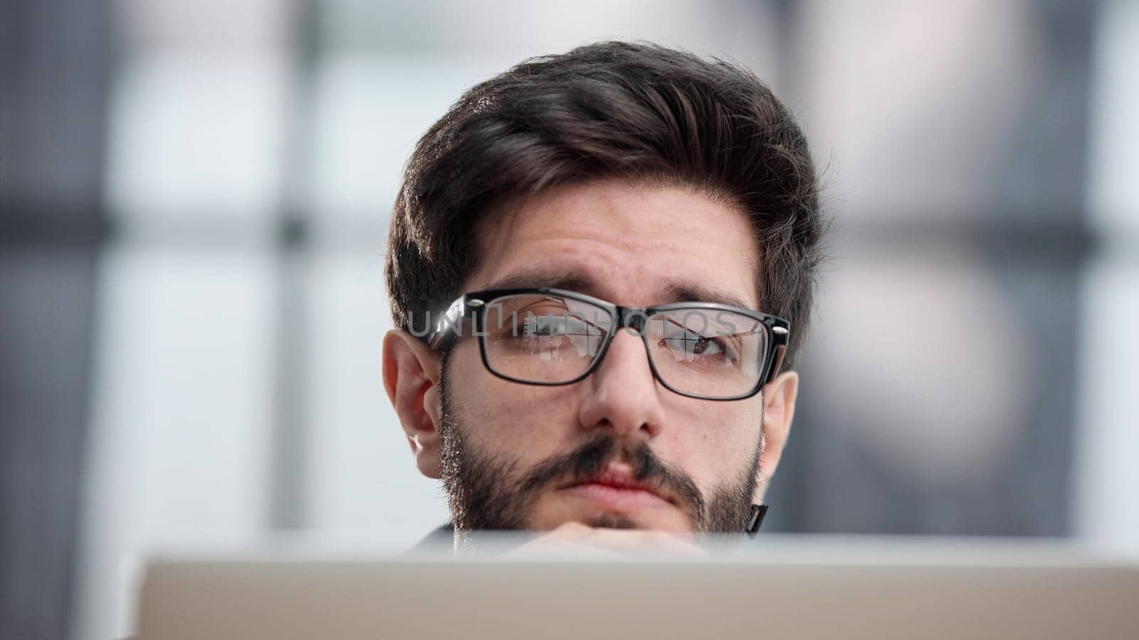 focused young businessman looking at computer monitor