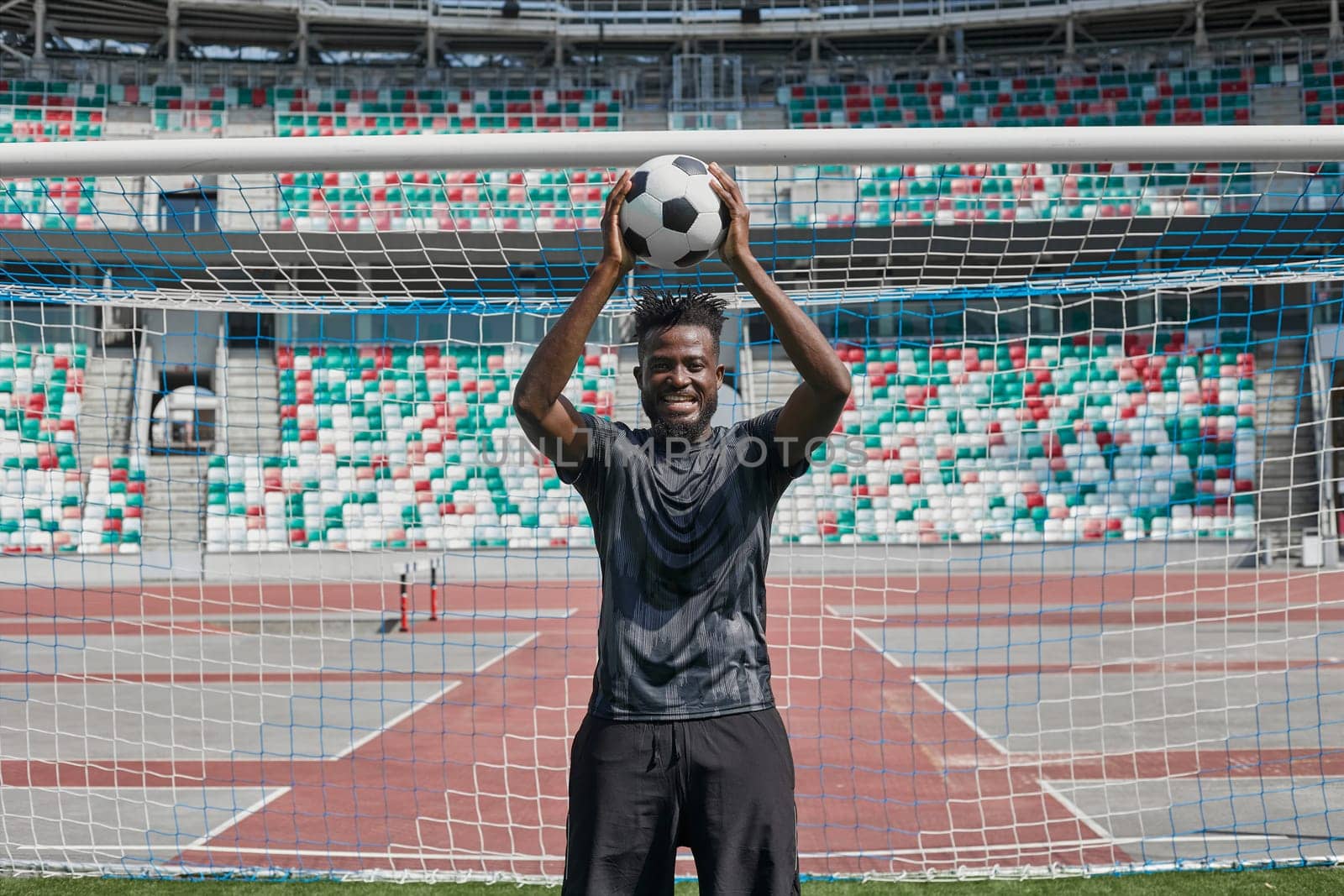 african american football player holding the ball in his hands at the stadium