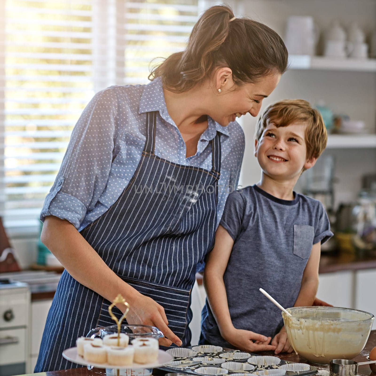 Mommy, can I help you. a mother and her son baking something in the kitchen