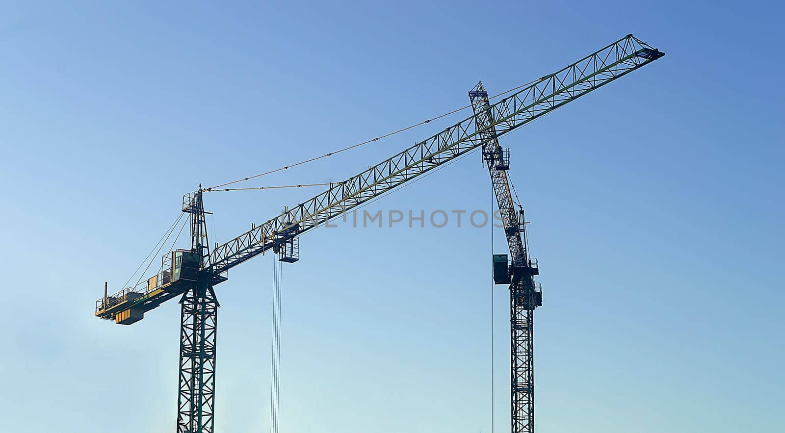 Two construction crane on blue sky by andre_dechapelle