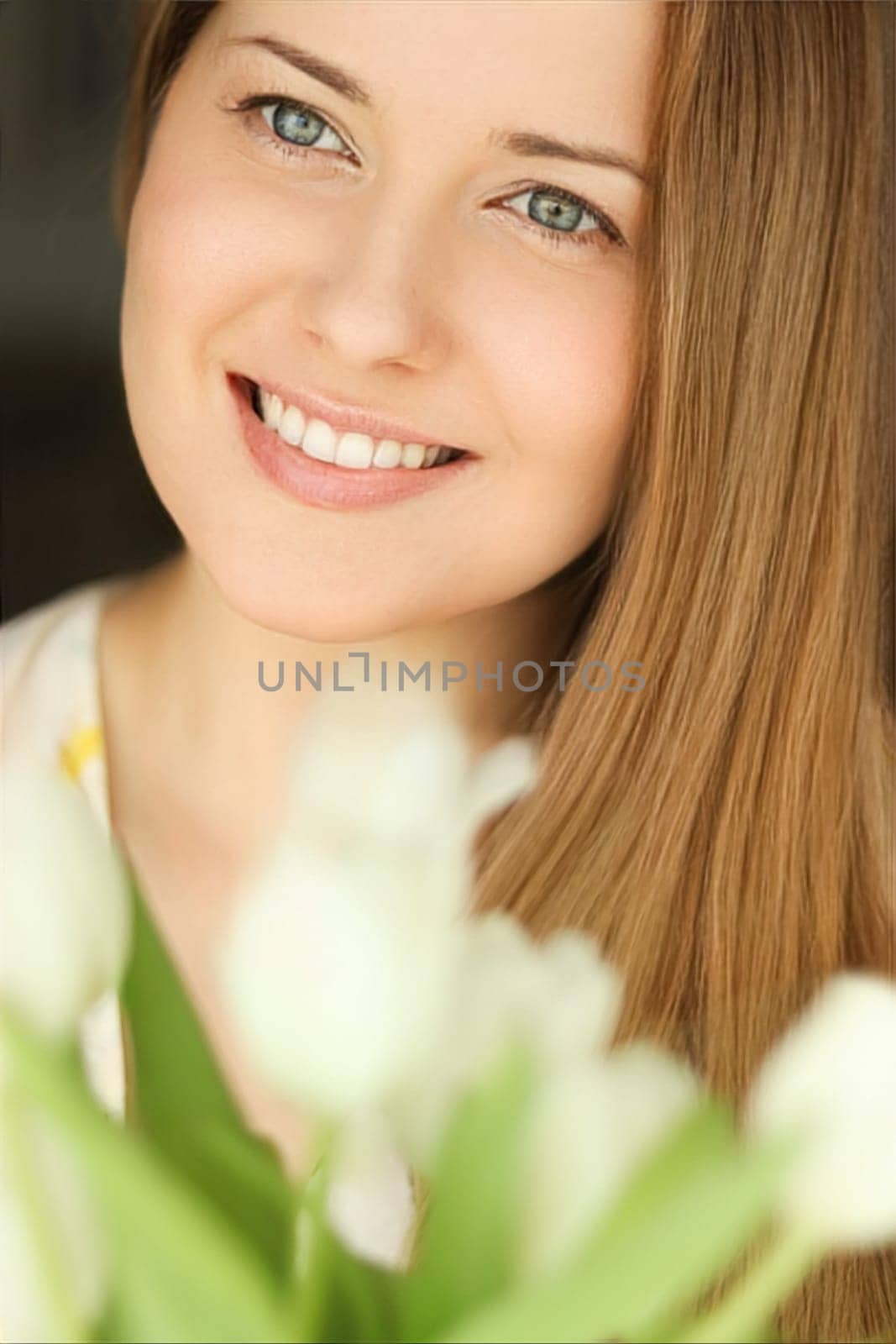 Happy woman with bouquet of flowers, face portrait with natural make-up, lifestyle at home.