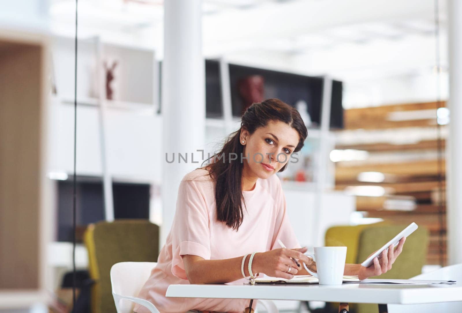 This tablet has really made business easy. Cropped portrait of a young businsswoman using a digital tablet at her desk in the office. by YuriArcurs