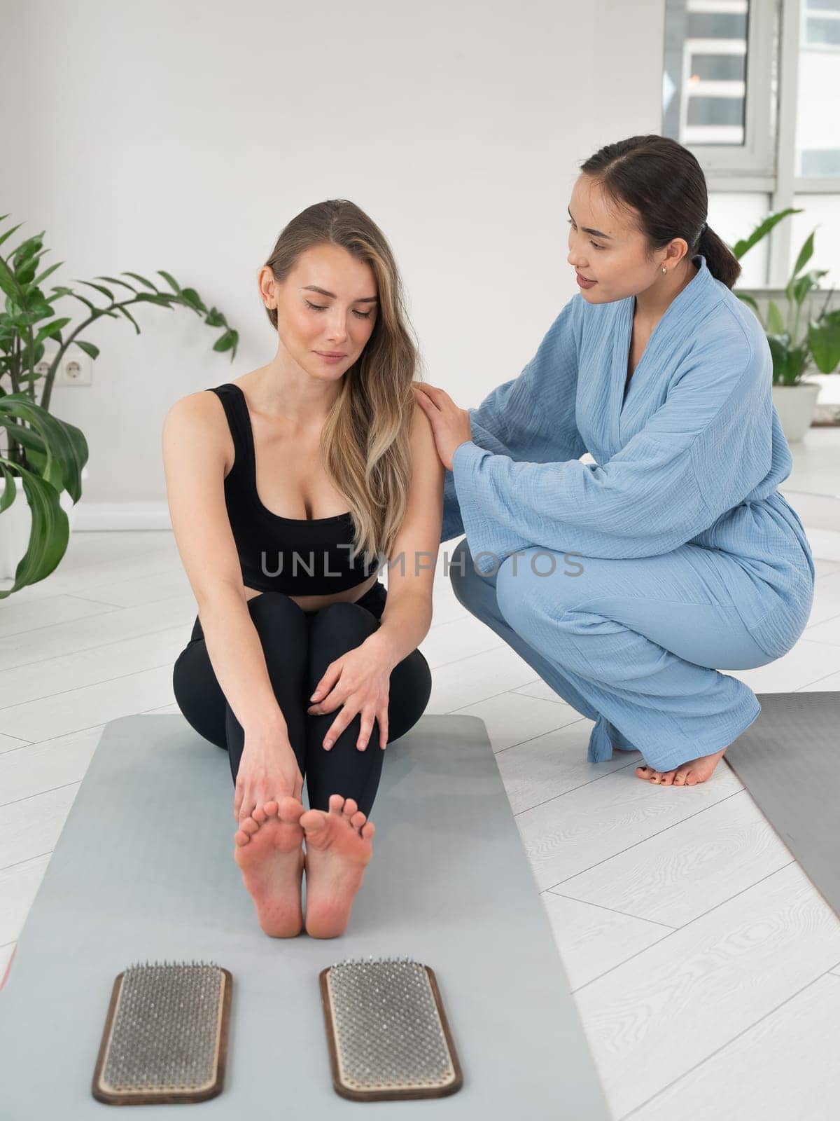 The therapist supports the client after standing on the sadhu boards. Nailing practice