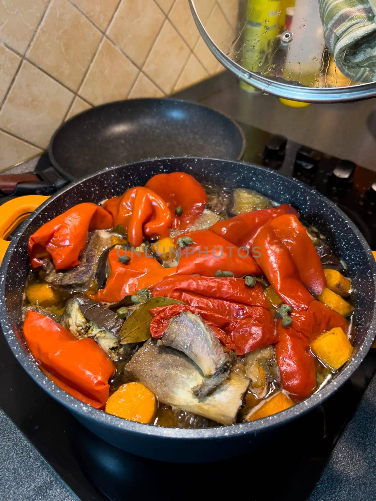Colorful fragrant lecho is cooked in a frying pan on the stove. High quality photo