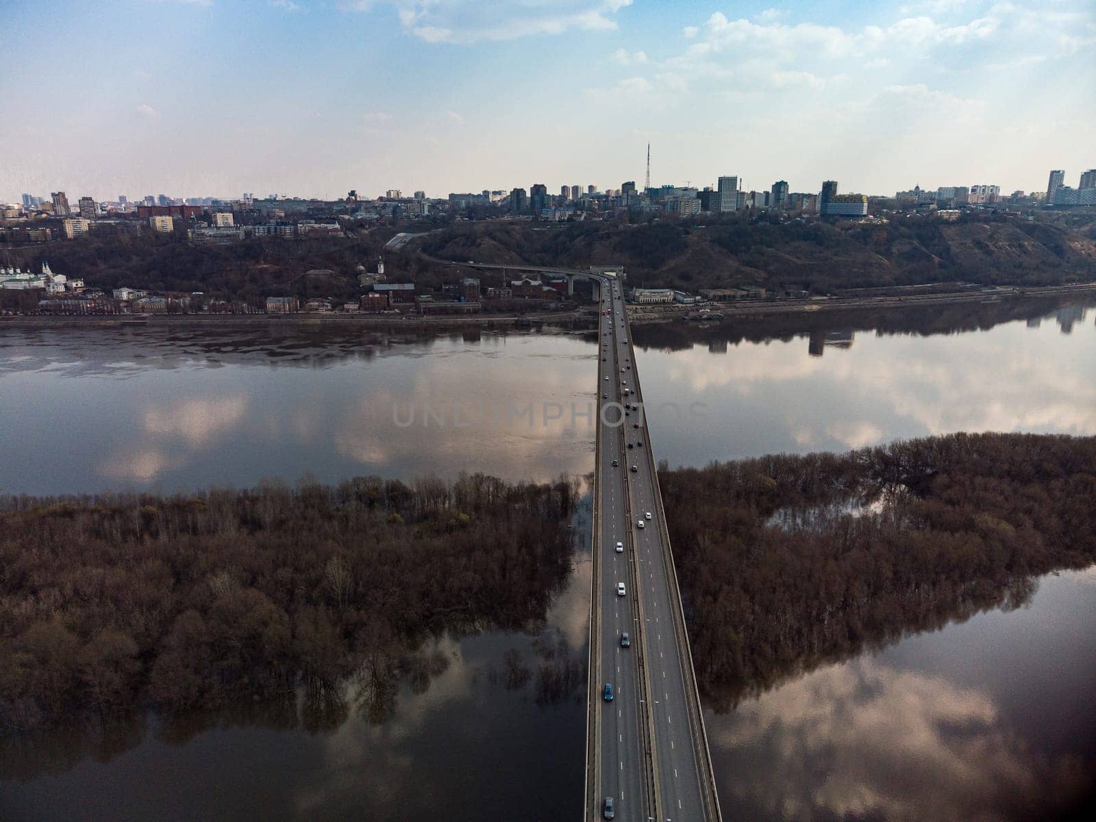 A road bridge over the river, taken from a quadrocopter. Urban traffic.