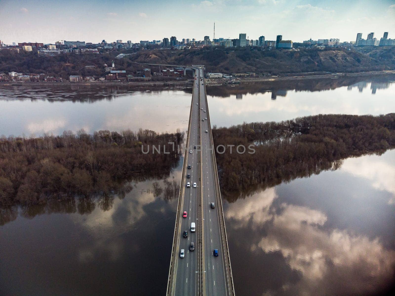 A road bridge over the river, taken from a quadrocopter. Urban traffic.