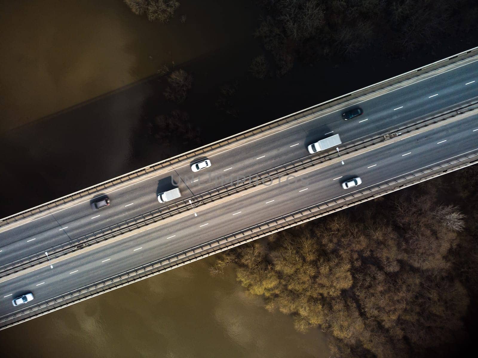 A road bridge over the river, taken from a quadrocopter. Urban traffic.