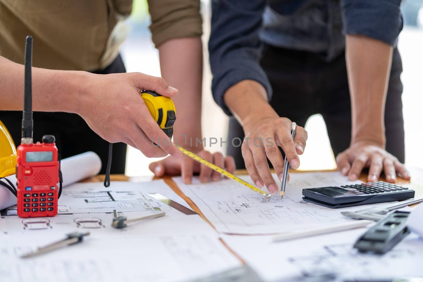 Young engineer architect sketching drawing project plan building construction, closed up cooperation corporate by wuttichaicci