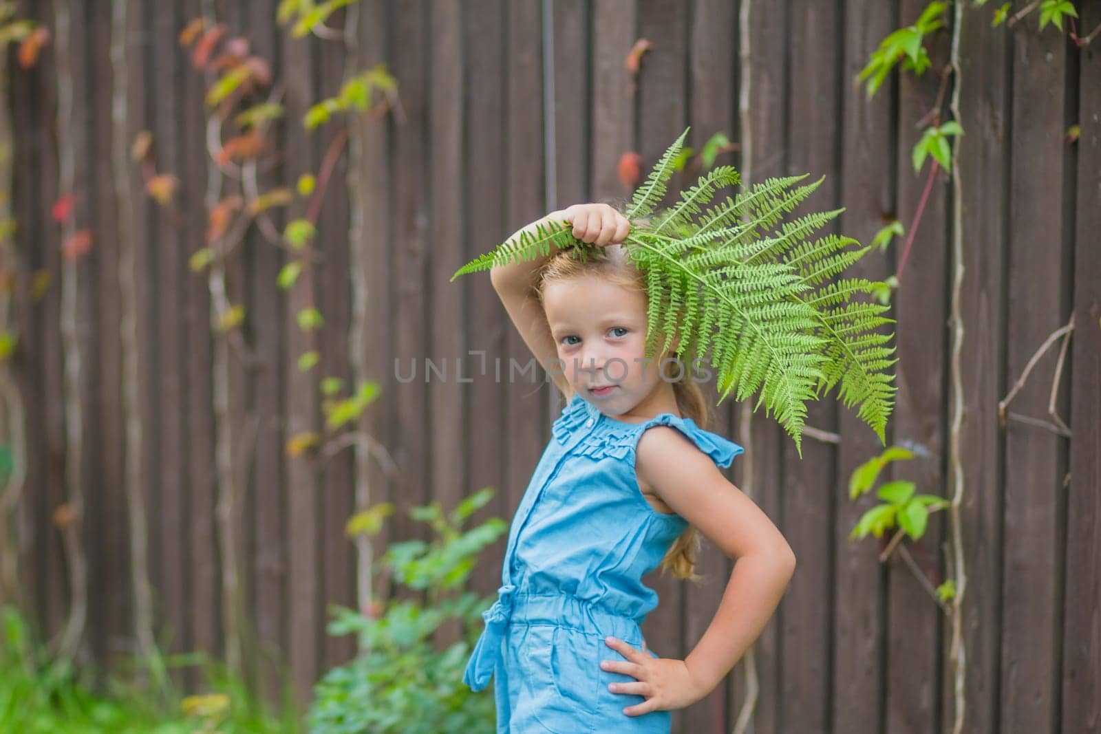 child girl dancing in the field park. happy childhood a family friendship concept. girl kid whirls in a blue dress in grass in the summer park. daughter in dancing whirls in the summer in nature sun