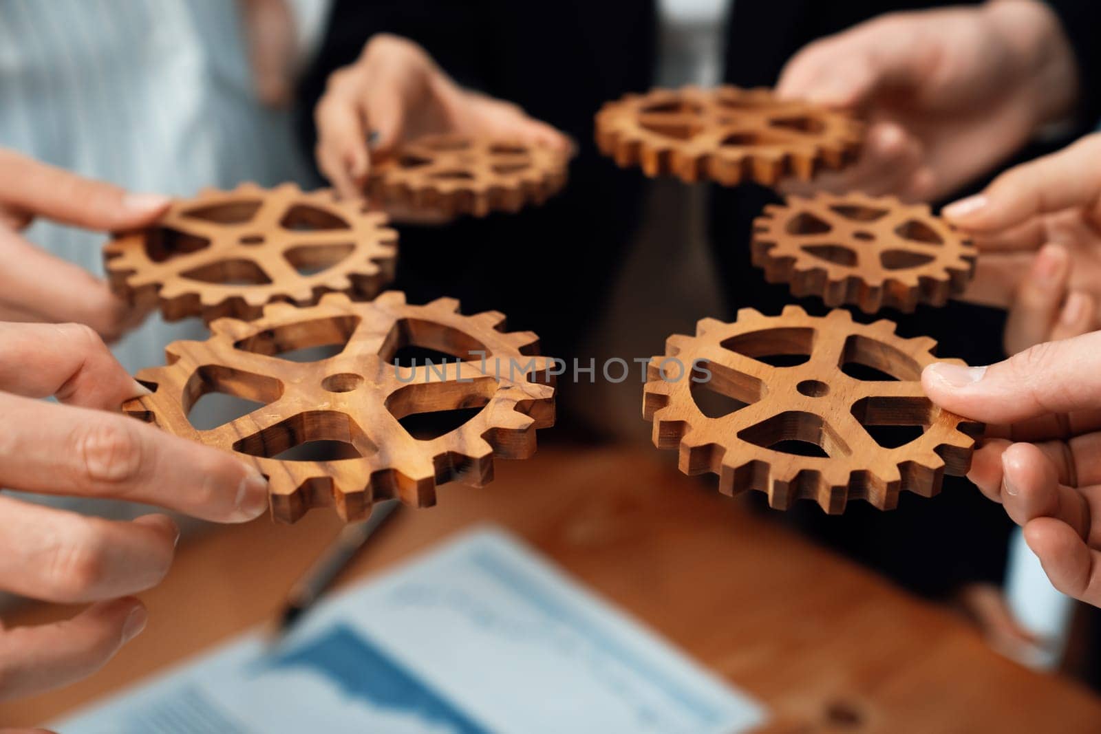 Group of people making chain of gears into collective form for harmony symbol. by biancoblue