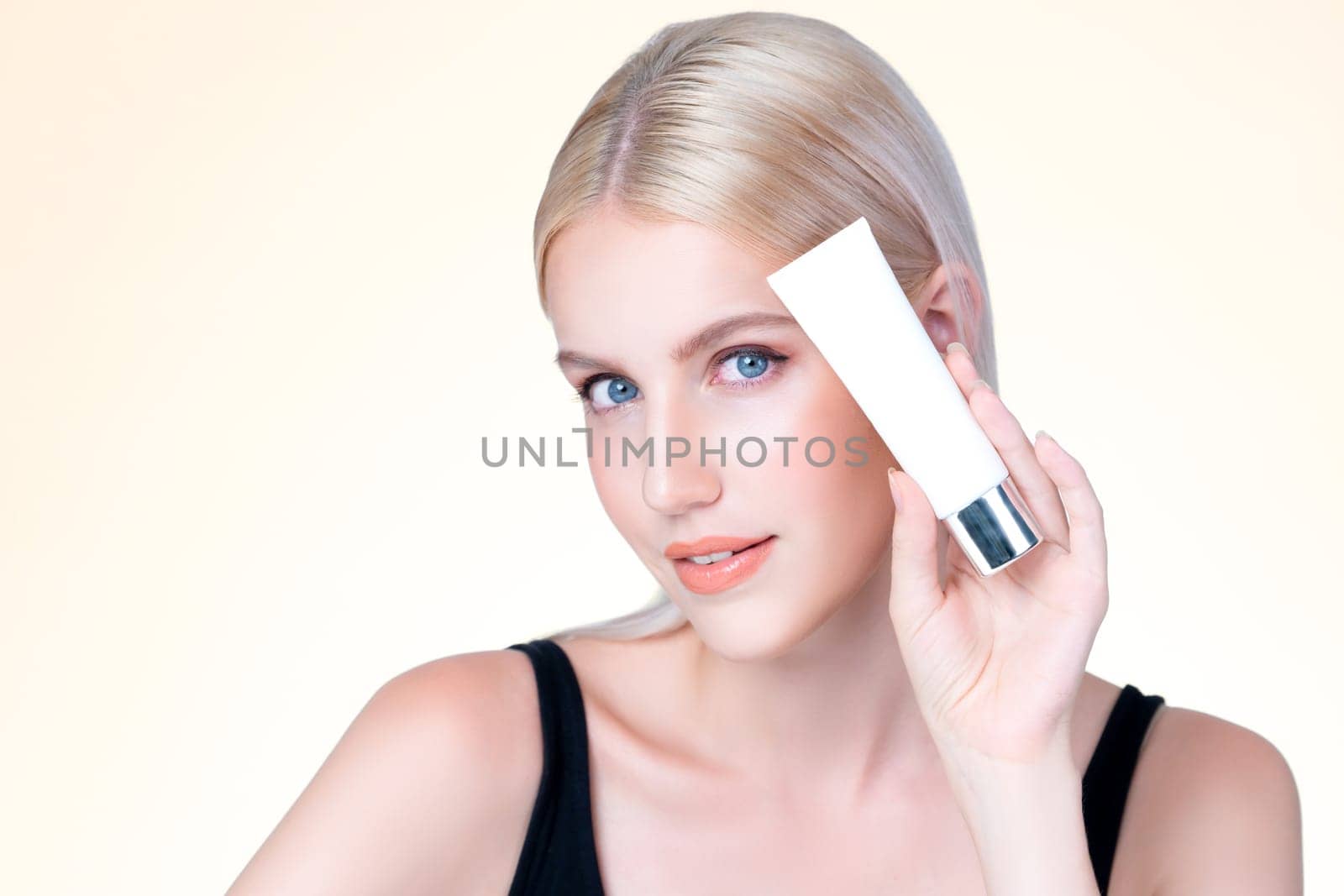 Personable beautiful perfect natural cosmetic makeup skin woman holding mockup tube moisturizer cream for healthy skincare treatment, anti-aging product advertisement in isolated background.