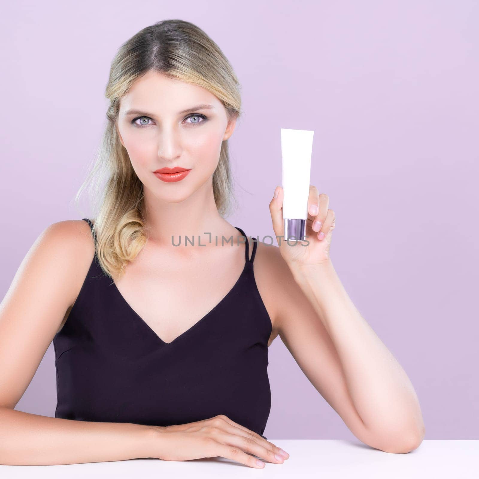 Alluring beautiful perfect cosmetic skin woman portrait hold mockup tube cream or moisturizer for skincare treatment, anti-aging product in pink isolated background. Natural healthy skin model concept