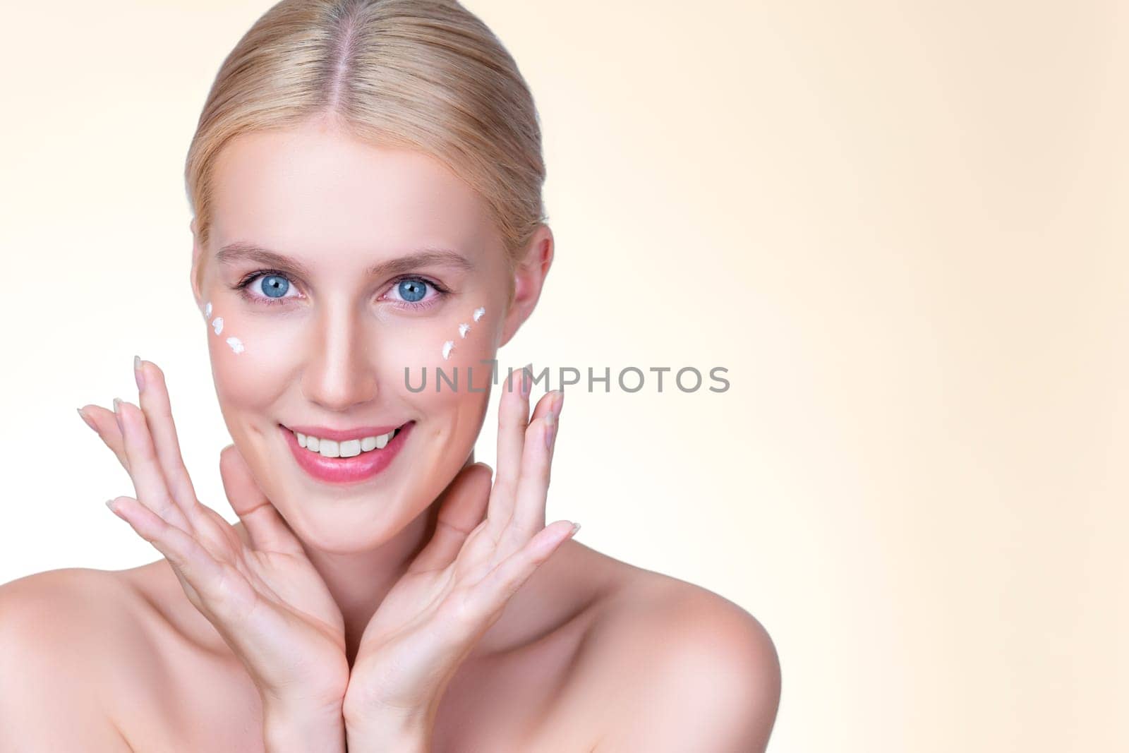 Personable beautiful perfect clean skin soft makeup woman finger applying moisturizer cream on her face under contour eye for anti aging wrinkle. Facial skin rejuvenation in isolated background.
