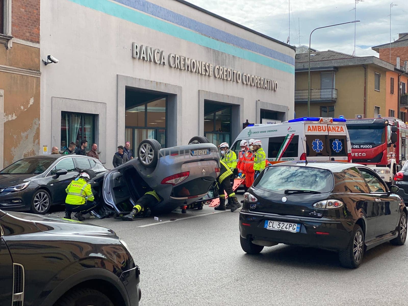 Cremona, Italy - 18th April 2023 just rolled over crashed car after an accident, police officer helping with traffic