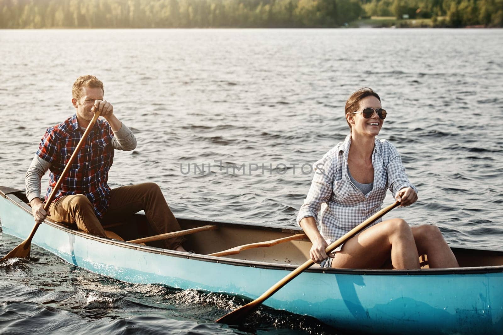Romance grows with every row. a young couple going for a canoe ride on the lake