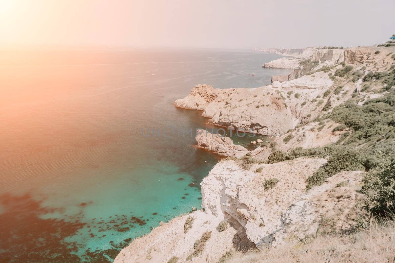 Aerial view from above on calm azure sea and volcanic rocky shores. Small waves on water surface in motion blur. Nature summer ocean sea beach background. Nobody. Holiday, vacation and travel concept by panophotograph