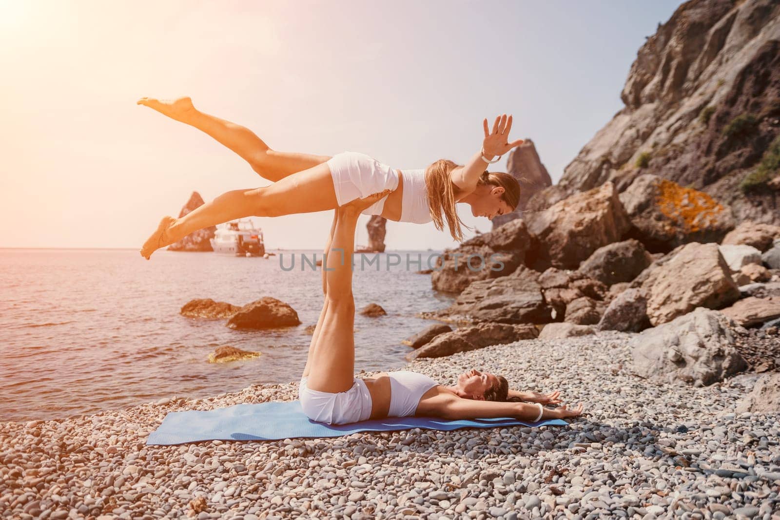 Woman sea yoga. Back view of free calm happy satisfied woman with long hair standing on top rock with yoga position against of sky by the sea. Healthy lifestyle outdoors in nature, fitness concept.