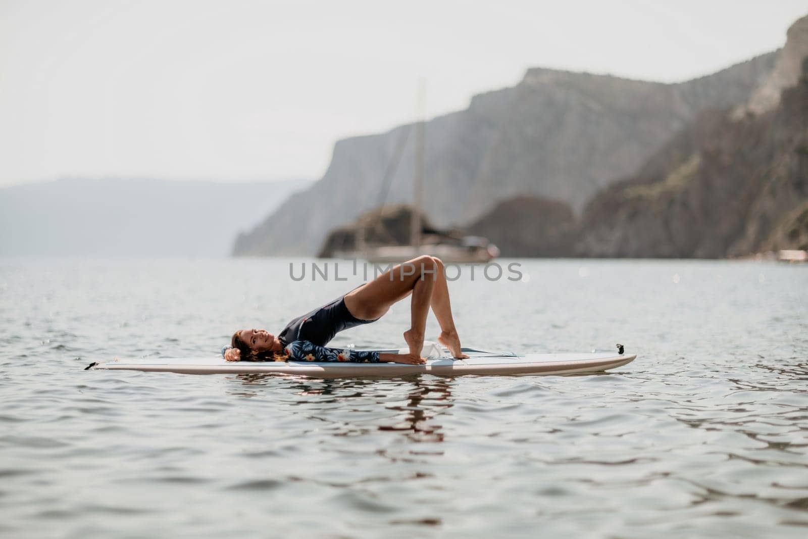 Woman sup yoga. Middle age sporty woman practising yoga pilates by panophotograph