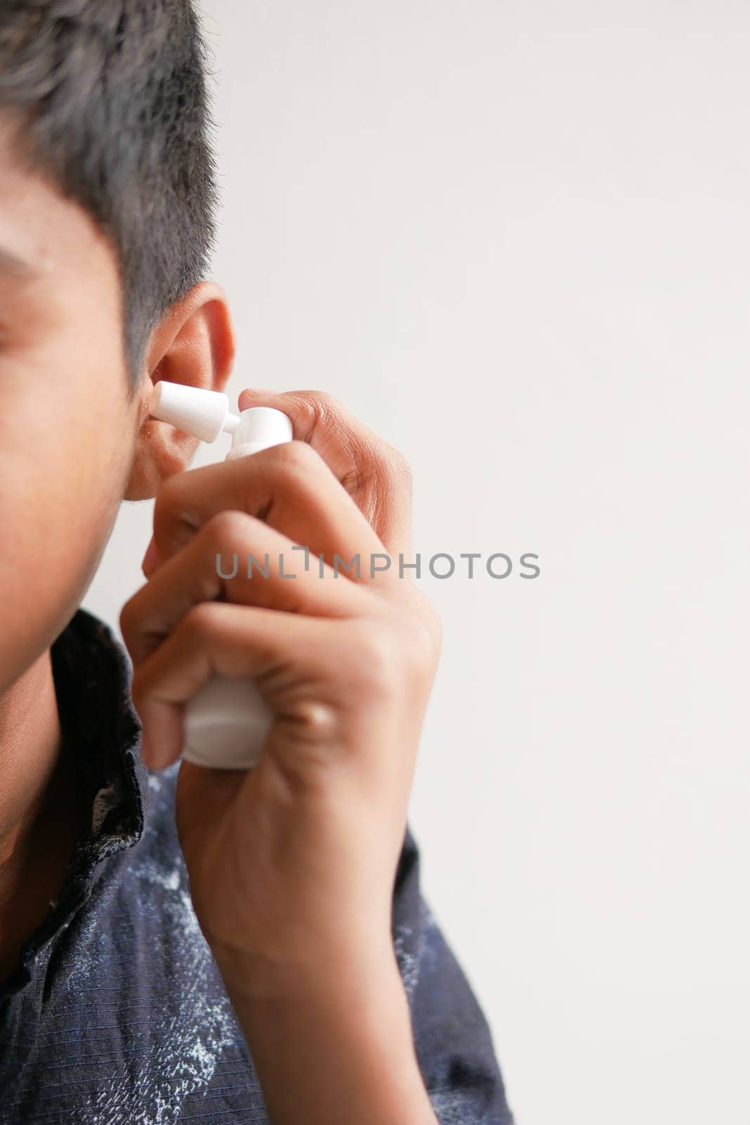 Close up of men using spray to remove earwax by towfiq007