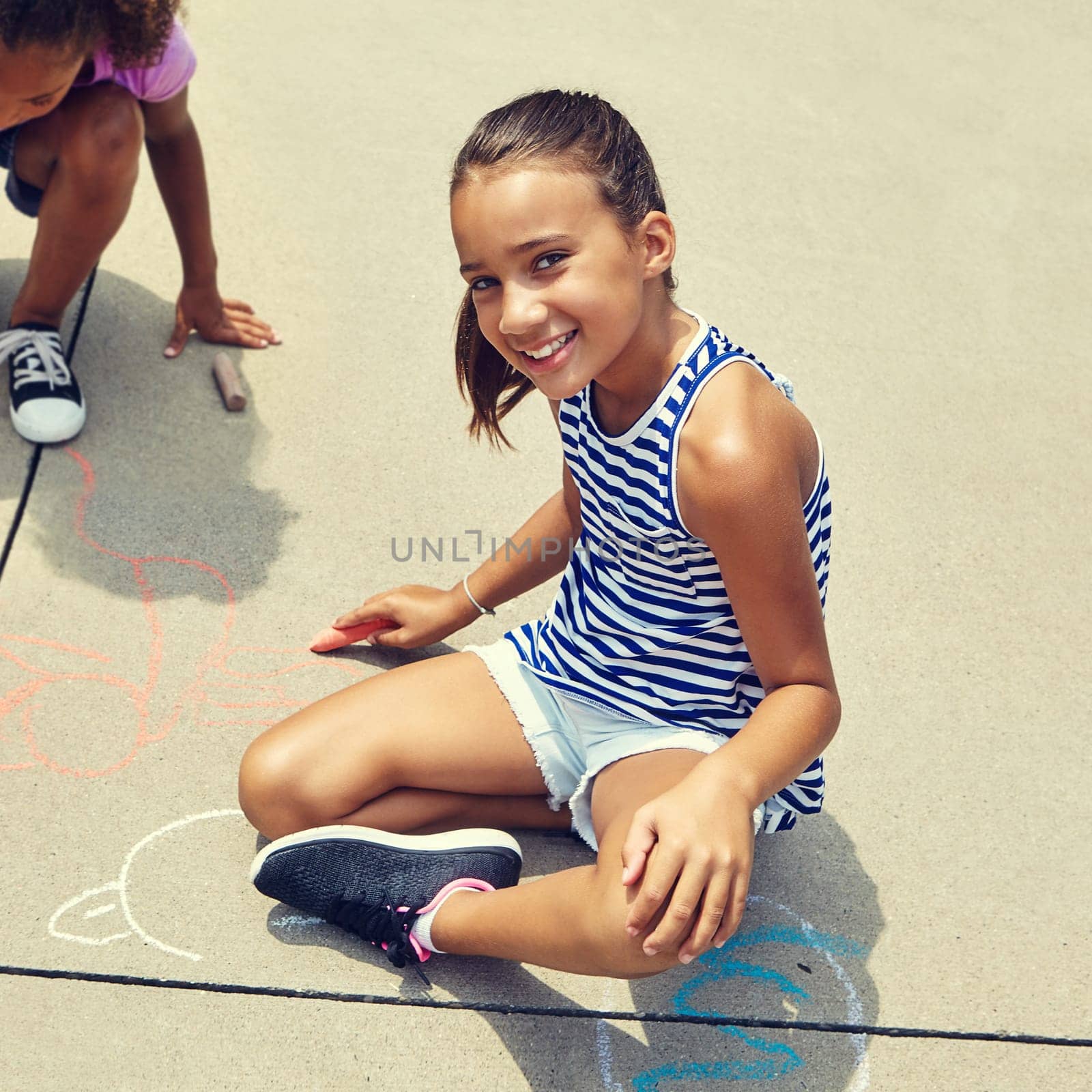 Getting creative with chalk. adorable little girls drawing with chalk on the pavement outdoors. by YuriArcurs