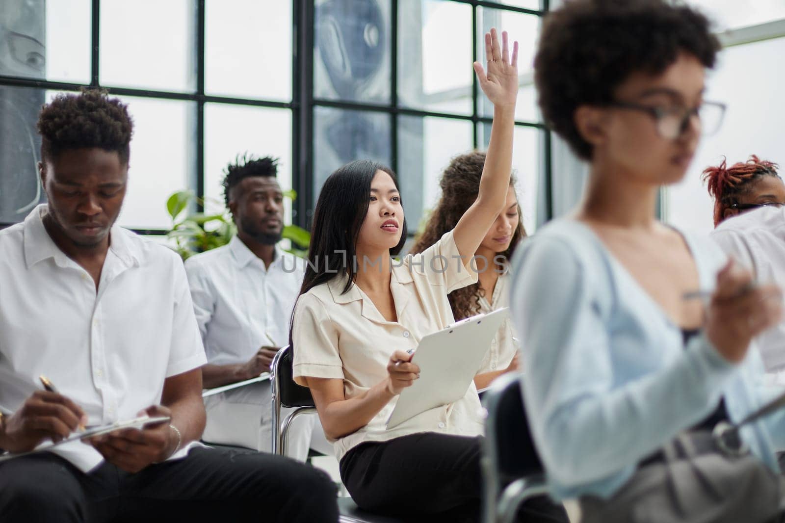 Group of different employees studying at board meeting in modern office or conference room