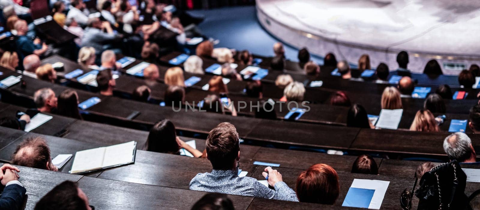 Business and entrepreneurship symposium. Audience in conference hall. Rear view of unrecognized participant in audience. by kasto