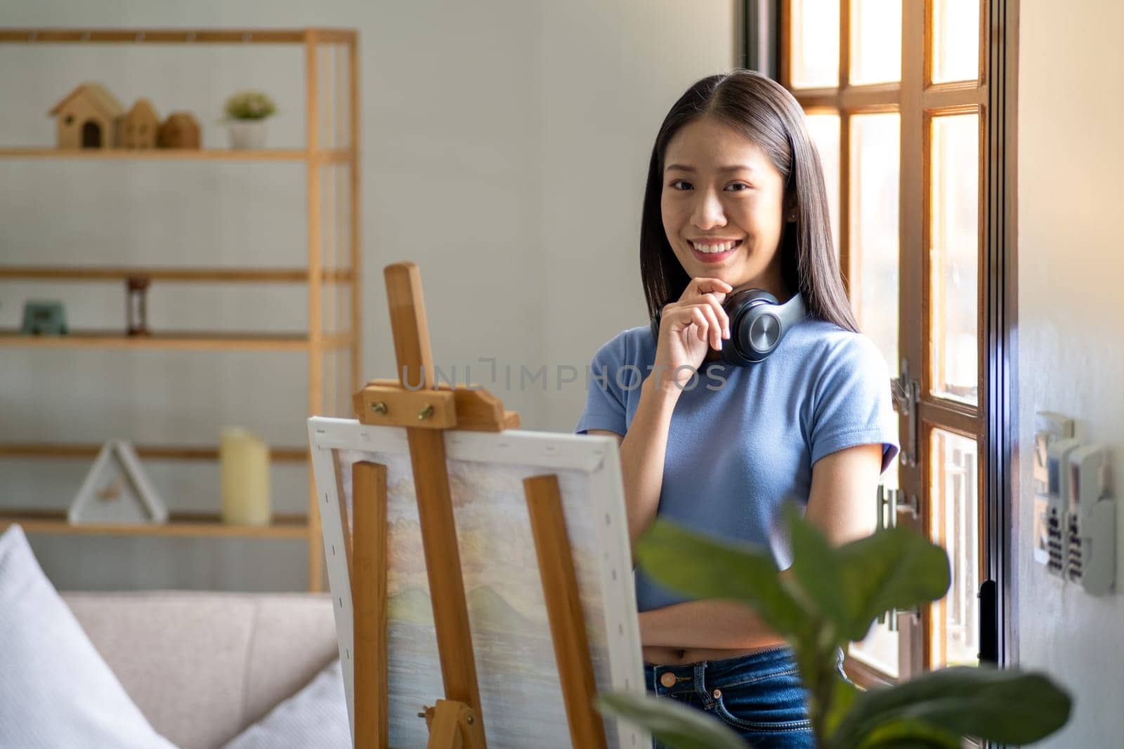 Young happy chilling creative Asian female painting working drawing finish picture at home. High quality photo