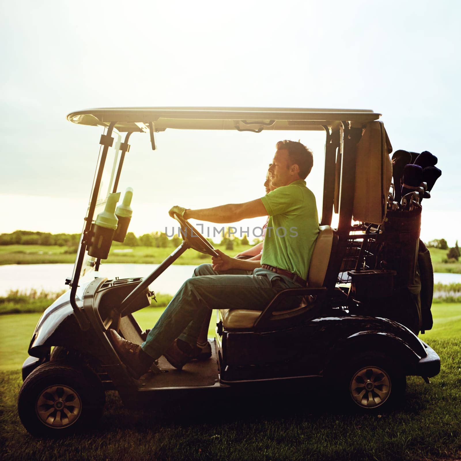 Their first date is right on course. a couple riding in a golf cart on a golf course