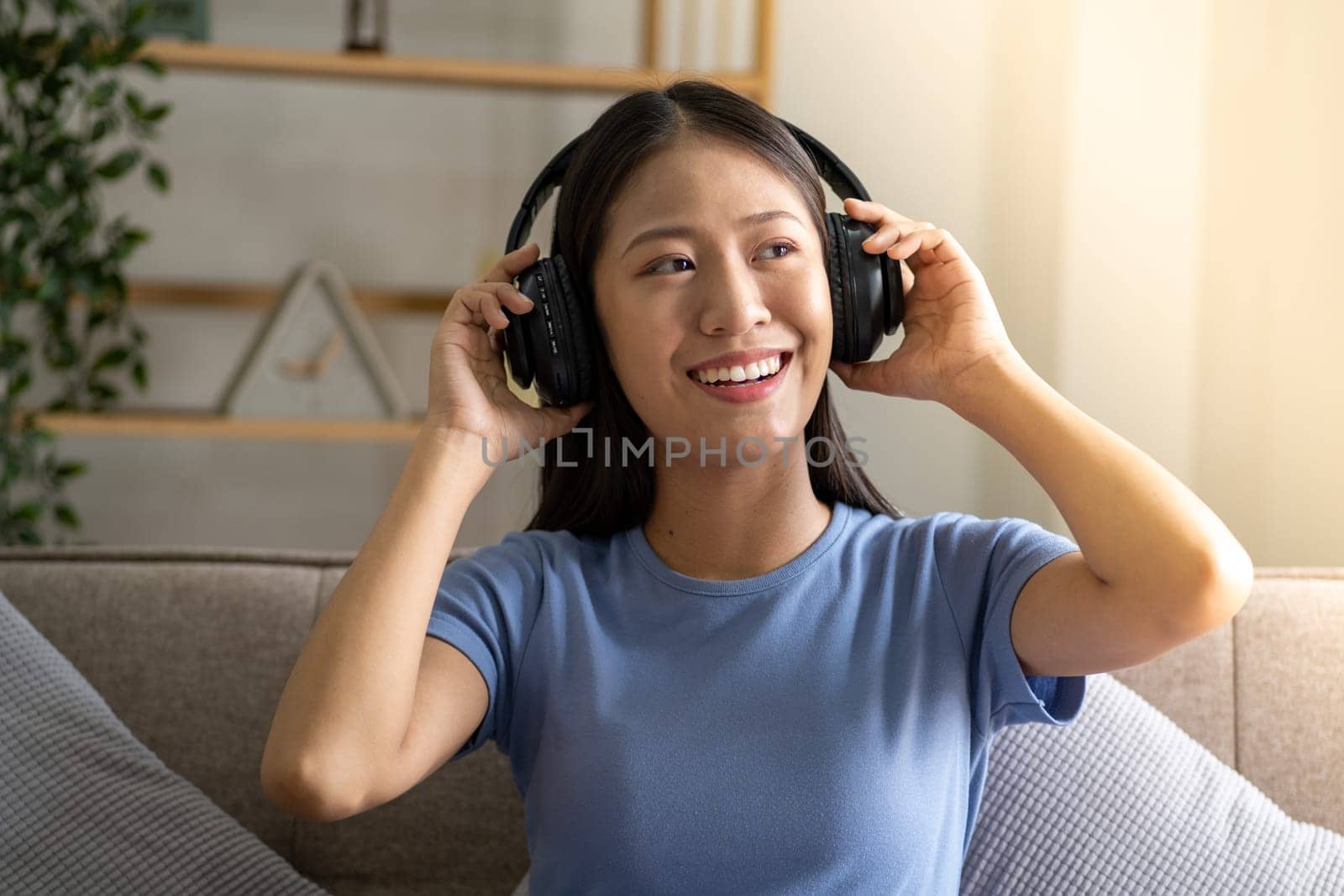 Beautiful young smart teenager woman with headphones relaxing on the bed sofa at home, Happy young teenager Asian listen by wuttichaicci