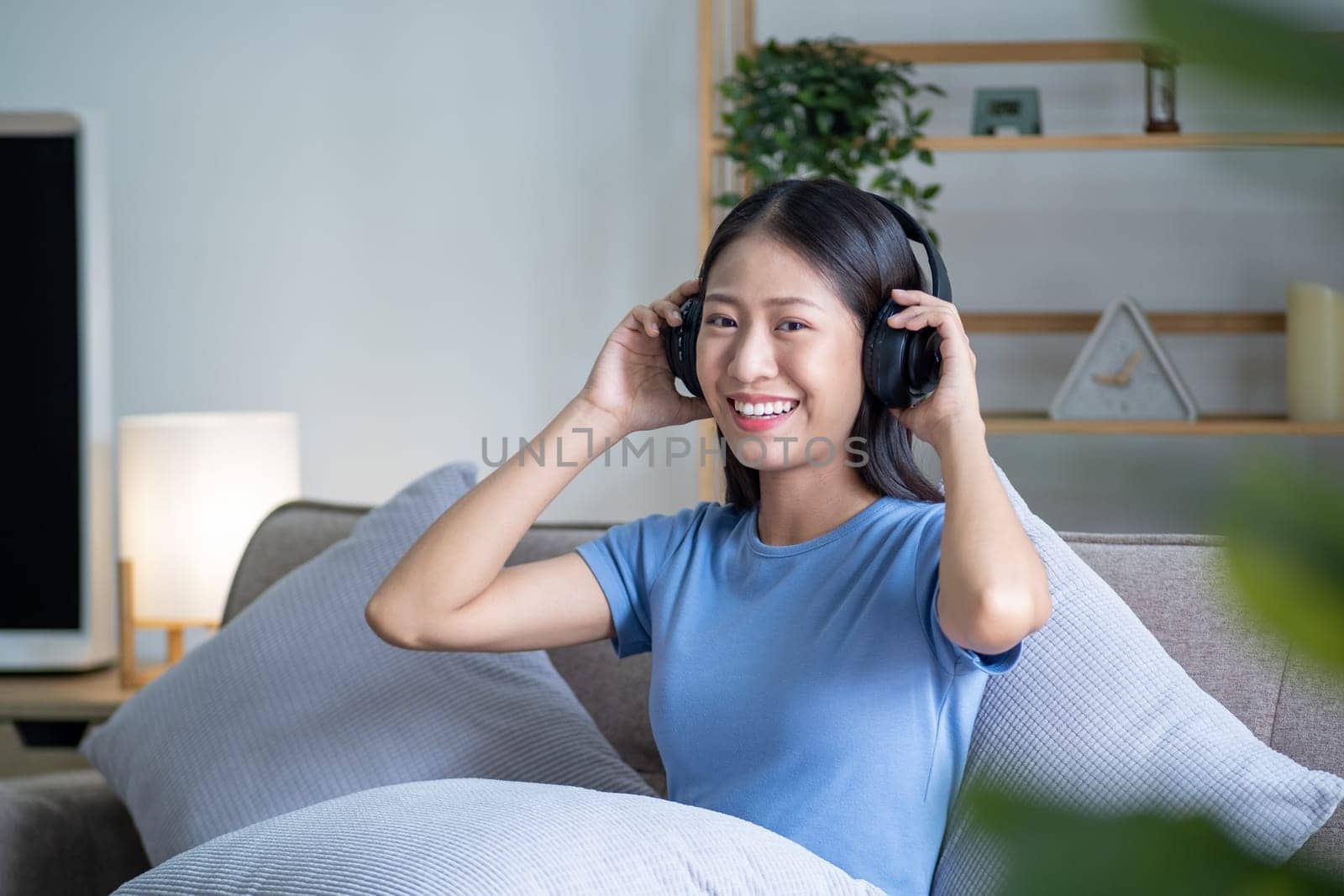 Beautiful young smart teenager woman with headphones relaxing on the bed sofa at home, Happy young teenager Asian listen relaxing song at home. High quality photo