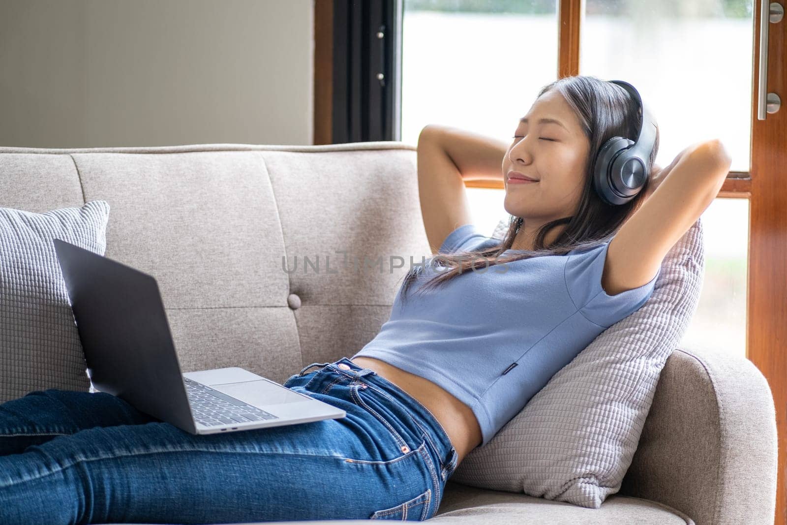 Beautiful young smart teenager woman with headphones relaxing on the bed sofa at home, Happy young teenager Asian listen by wuttichaicci