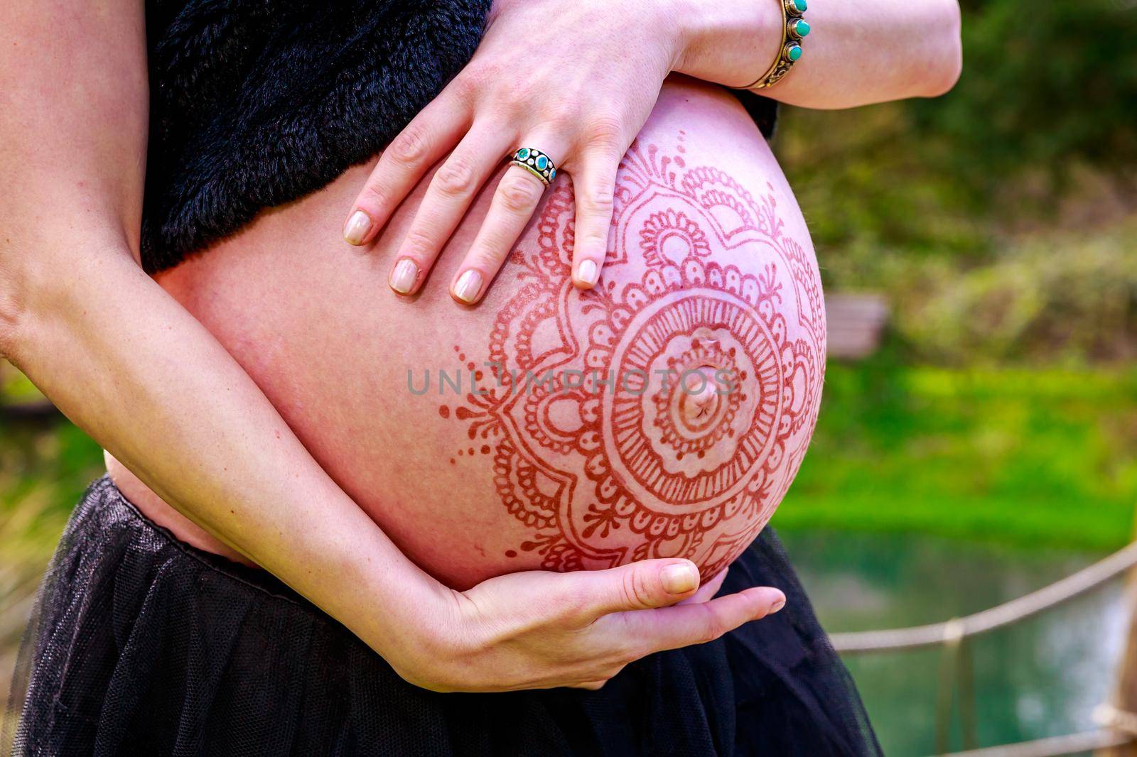 Young beautiful woman with pregnant belly showing.