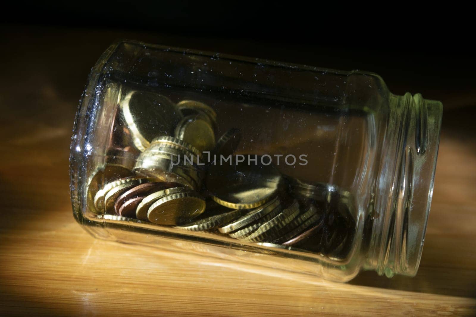 glass jar full of coins for savings concept