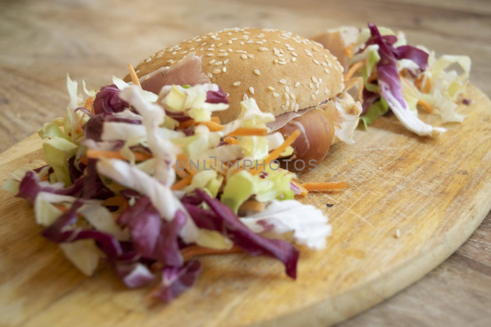 round sandwich filled with salad and raw ham