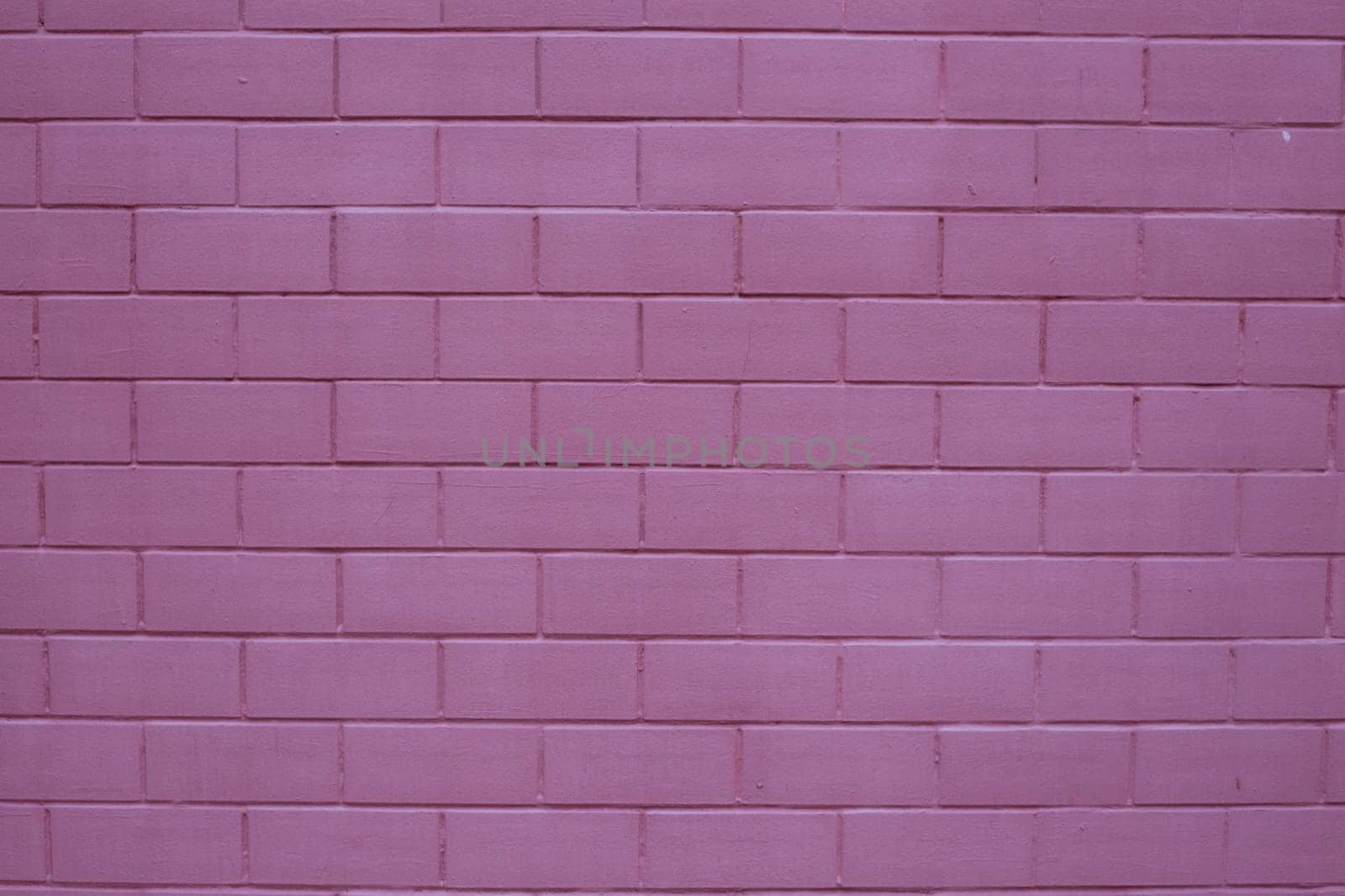 Painted brick wall in pink purple paint texture stone background