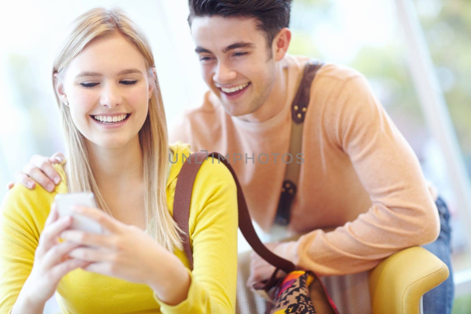 Romance and a cellphone. Young teen couple reading texts on a cellphone