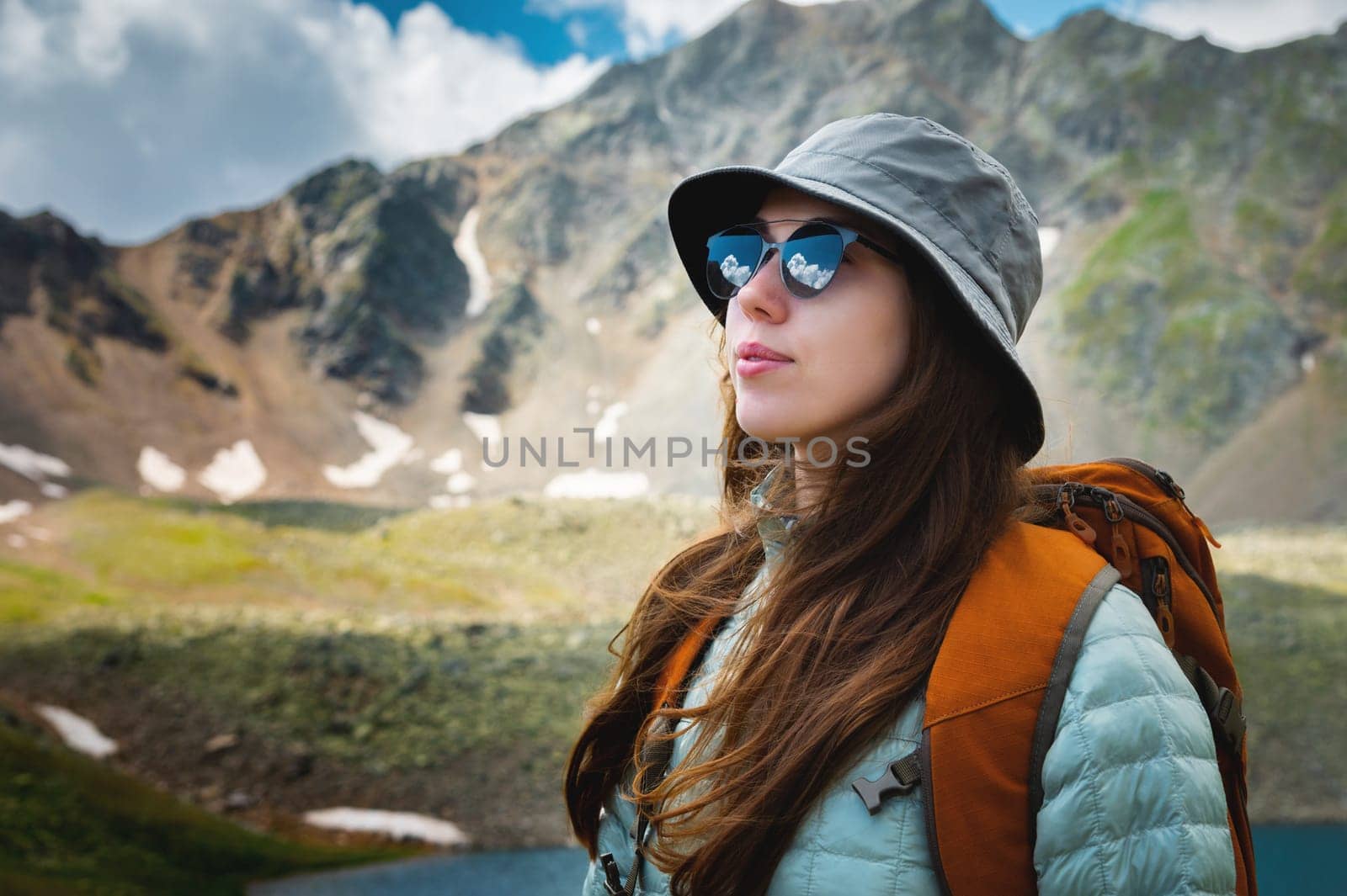 Happy, woman and female student with a backpack outdoors in the mountains resting during the holidays. freedom concept. Portrait of a girl in sunglasses during a walk.