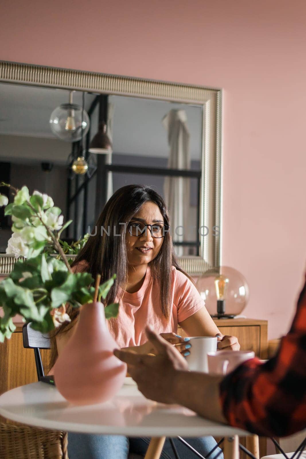 Happy couple eating breakfast and talking at dining table in morning. Indian girl and latino guy. Relationship and diversity concept by Satura86