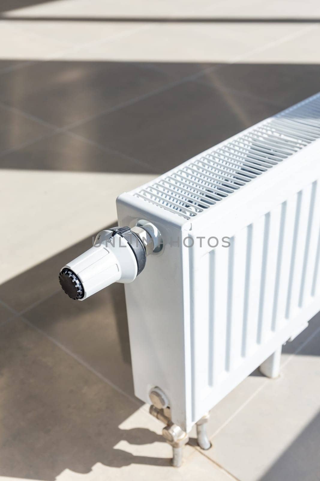 Close-up of white central heating floor radiator with a power regulator in the maximum position.