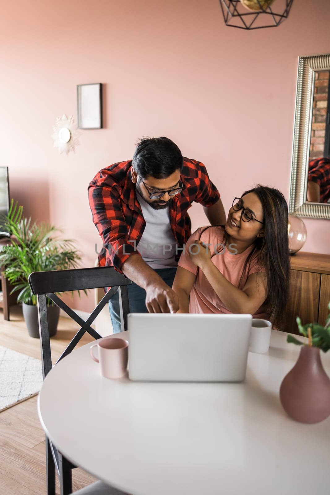 technology remote job and lifestyle concept - happy indian man and woman in glasses with laptop computer working at home office by Satura86