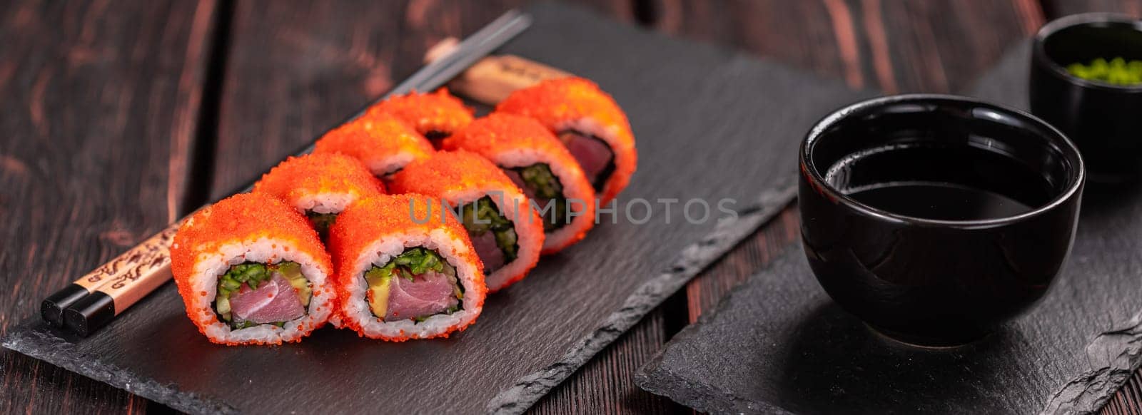 Banner California sushi roll with eel, cucumber and tobiko caviar served on black board close-up - Japanese food by Satura86